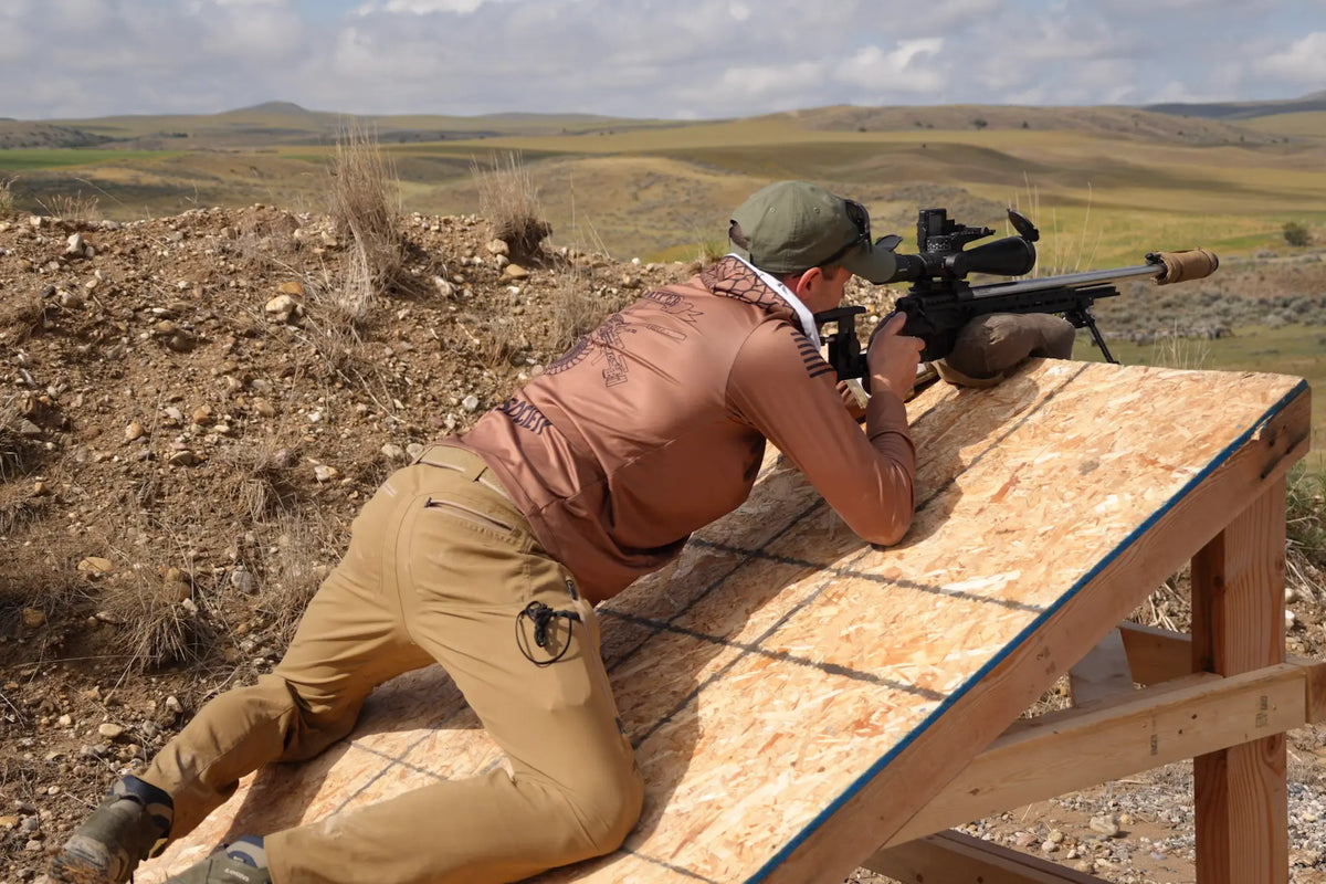Bad Dope Society sun shirt, tan, prone shooting off an angled rooftop-simulator barricade